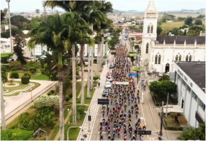 Multidão de ciclistas cruzando o centro de Amargosa durante o Amarider, com destaque para a Catedral ao fundo